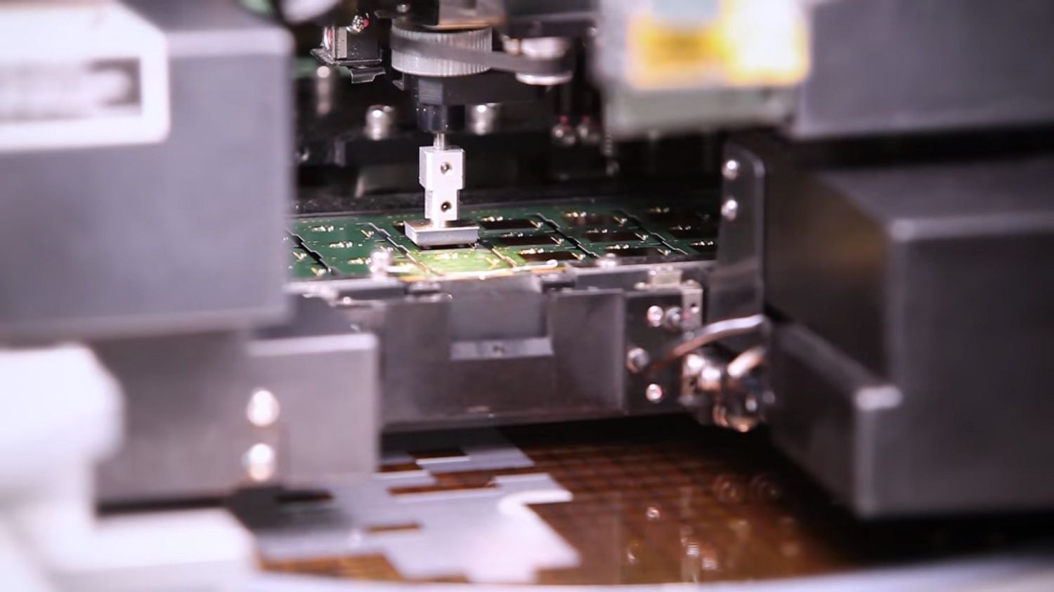 Una máquina recoge un chip de un alimentador y lo coloca en la PCB