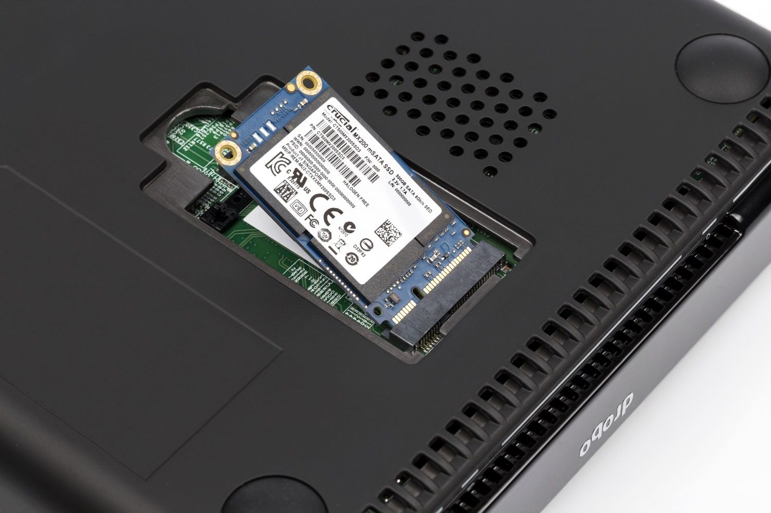 Una SSD MSATA Crucial MX200 siendo insertada en un portátil